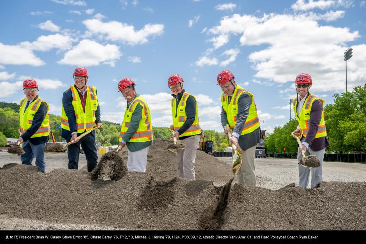 Six people wearing hardhats and holding shovels