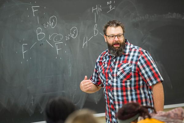 Professor in front of a chalkboard addressing classroom